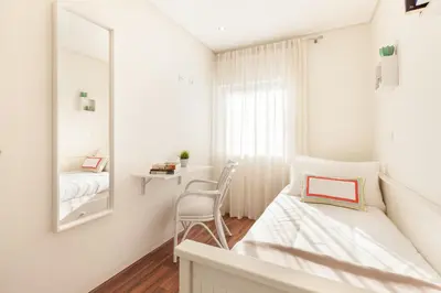 a white bedroom with a bed and a mirror at D&S - Torne Apartments in Vila Nova de Gaia