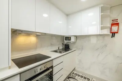 a white kitchen with a sink and a stove at D&S - Torne Apartments in Vila Nova de Gaia