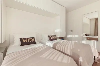 a white bedroom with two beds with pillows at D&S - Torne Apartments in Vila Nova de Gaia