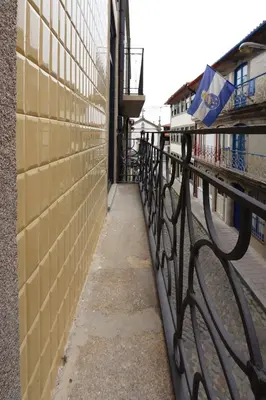 a black fence next to a street with a building at HM - Pinheiro Downtown Living in Porto
