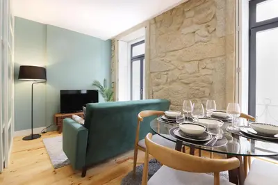 a living room with a table and a green couch at HM - Pinheiro Downtown Living in Porto