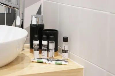 a bathroom counter with three bottles of cosmetics on it at HM - Pinheiro Downtown Living in Porto
