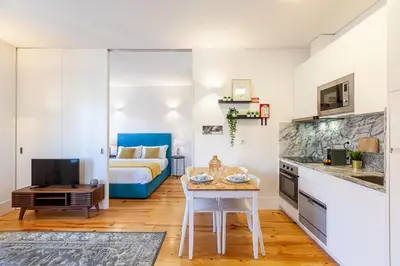 a kitchen and living room with a bed and a table at D&S - Porto São Bento Apartments III in Porto