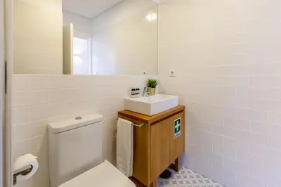 a bathroom with a white toilet and a sink at D&S - Porto São Bento Apartments III in Porto