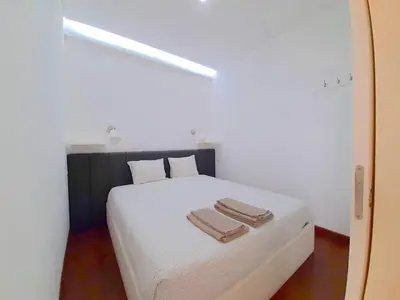 a bedroom with a white bed with two towels on it at VB Porto City Apartment by Flat in Porto in Porto