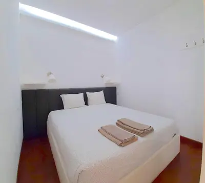 a bedroom with a white bed with two towels on it at VB Porto City Apartment by Flat in Porto in Porto