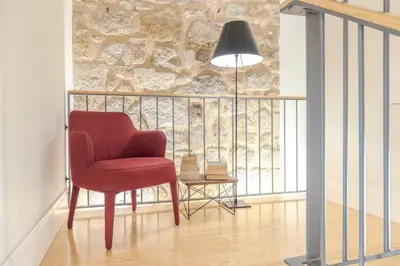 a red chair sitting on a balcony with a lamp at Wonderful Porto Design Apartments in Porto