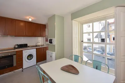 a kitchen with a table and chairs and a window at Vitoria Apartments in Porto