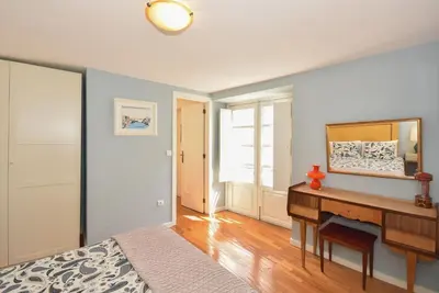 a bedroom with a bed and a desk and a mirror at Vitoria Apartments in Porto