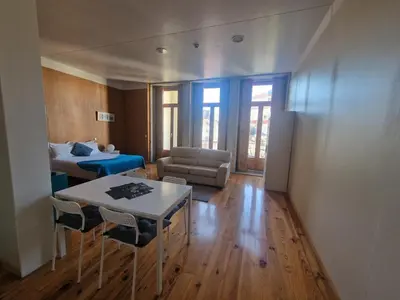 a living room with a bed and a table and chairs at Loulé Estúdios in Porto