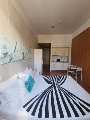 a bedroom with a large white bed with a striped pillow at Loulé Estúdios in Porto