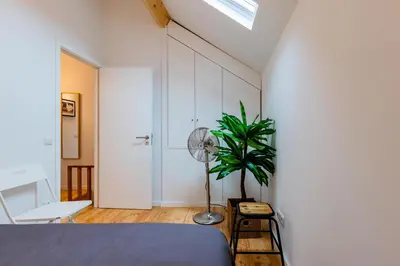 a bedroom with a bed and a fan and a plant at Design Boavista Music Home in Porto
