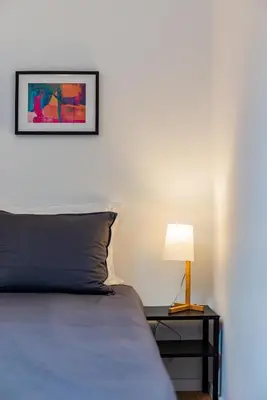 a bedroom with a bed and a table with a lamp at Design Boavista Music Home in Porto