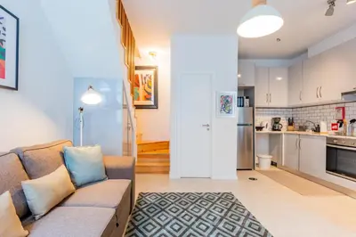 a living room with a couch and a kitchen at Design Boavista Music Home in Porto