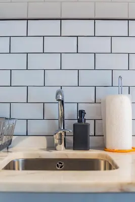a kitchen sink with a roll of paper towels at Design Boavista Music Home in Porto