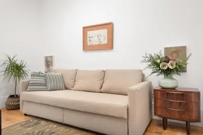 a couch in a living room with a vase of flowers at Host Wise - Oporto Classic Apartment in Porto