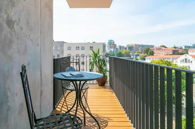 a patio with a table and chairs on a balcony at Porto Insight Cedofeita- Parking, Balconies & AC in Porto