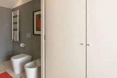a bathroom with a white toilet and a sink at Porto Insight Cedofeita- Parking, Balconies & AC in Porto