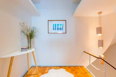 a room with white walls and a table with a vase at UNIQUE Modernist Duplex apartment & PARKING in Porto