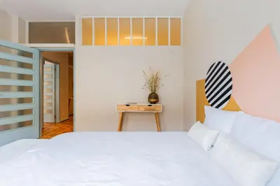 a bedroom with a white bed and a table at UNIQUE Modernist Duplex apartment & PARKING in Porto