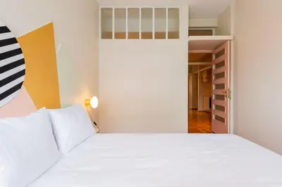 a bedroom with a white bed and a closet at AMAZING DUPLEX - Mid Century Experience & PARKING in Porto