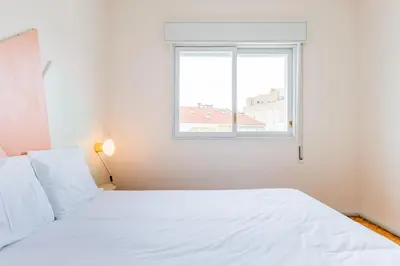 a white bed in a room with a window at INCREDIBLE DUPLEX PENTHOUSE & TERRACES & Parking in Porto