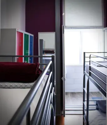 a room with two bunk beds and a wooden floor at By Doors Hostel in Porto