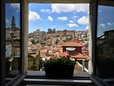 two glasses of wine sitting on a table in front of a window at Urban Apartment Casa da Portela in Porto