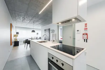 a kitchen with white cabinets and a sink at Cedofeita Lux Design in Porto