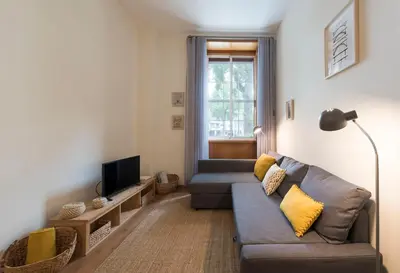 a living room with a couch and a tv at LovelyStay - The Porto Getaway w/ Free Parking in Porto
