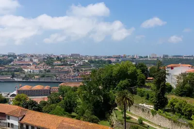 a balcony with two chairs and a bed at Tripas-Coração, Cordoaria River View, Garden View or Loft in Porto