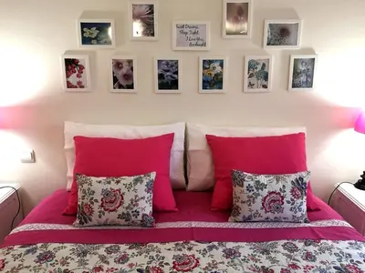 a bed with pink pillows and pictures on the wall at Architect House in Porto