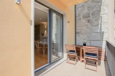 a patio with two chairs and a table on a balcony at Liiiving in Porto - Charming Downtown Delight in Porto
