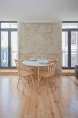 a table and chairs in a room with windows at Liiiving in Porto - Charming Downtown Delight in Porto