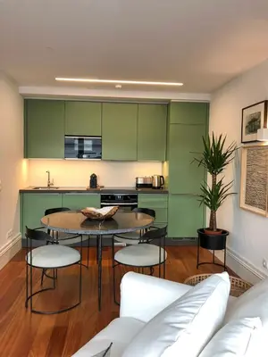 a kitchen with green cabinets and a table and chairs at Oporto Chic&Cozy - Aliados in Porto