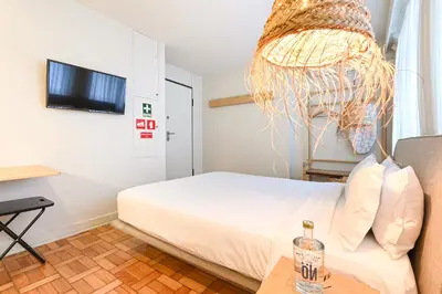 a bedroom with a bed and a table with a bottle on it at Sleep in Office in Porto