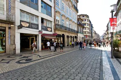 a group of people walking down a street with buildings at Sleep in Office in Porto