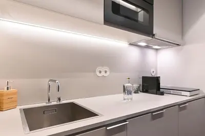 a kitchen counter with a sink and a microwave at Sleep in Office in Porto