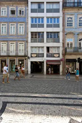 a group of people walking down a street in front of a building at Sleep in Office in Porto