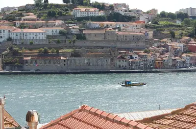 a boat in the water next to a city at Top Flat in Porto