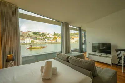 a room with a large window with a view of the water at LUXURY VIEWS by YoursPorto in Vila Nova de Gaia