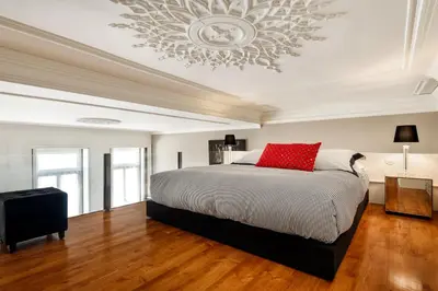 a bedroom with a large bed and a chandelier at Maison Cabral in Porto