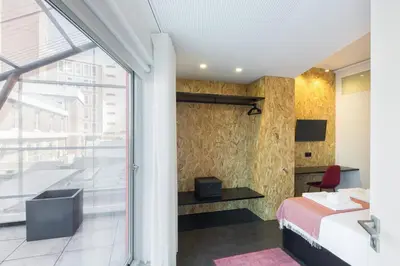 a bedroom with a bed and a large window at QP Trindade Apartments in Porto