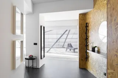 a hallway with white walls and a wooden door at QP Trindade Apartments in Porto