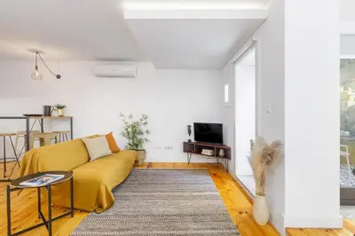 a living room with a yellow couch and a tv at Relax Porto Studio by Own Places in Porto