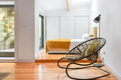a room with a chair and a bedroom with a bed at Relax Porto Studio by Own Places in Porto
