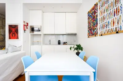 a white dining room with a white table and blue chairs at Spacious Duplex in Porto's Downtown • A/C in Porto