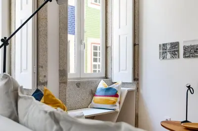 a room with windows and a bench with pillows at Spacious Duplex in Porto's Downtown • A/C in Porto