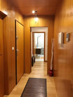 a hallway with wooden walls and a door with a rug at InPorto in Porto