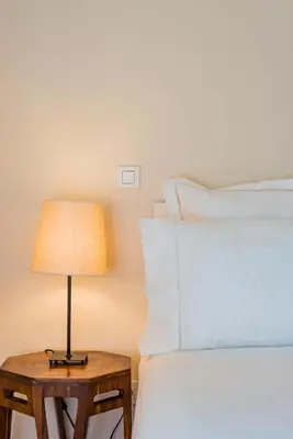 a bedside table with a lamp next to a bed at Boavista Garden Apartment in Porto
